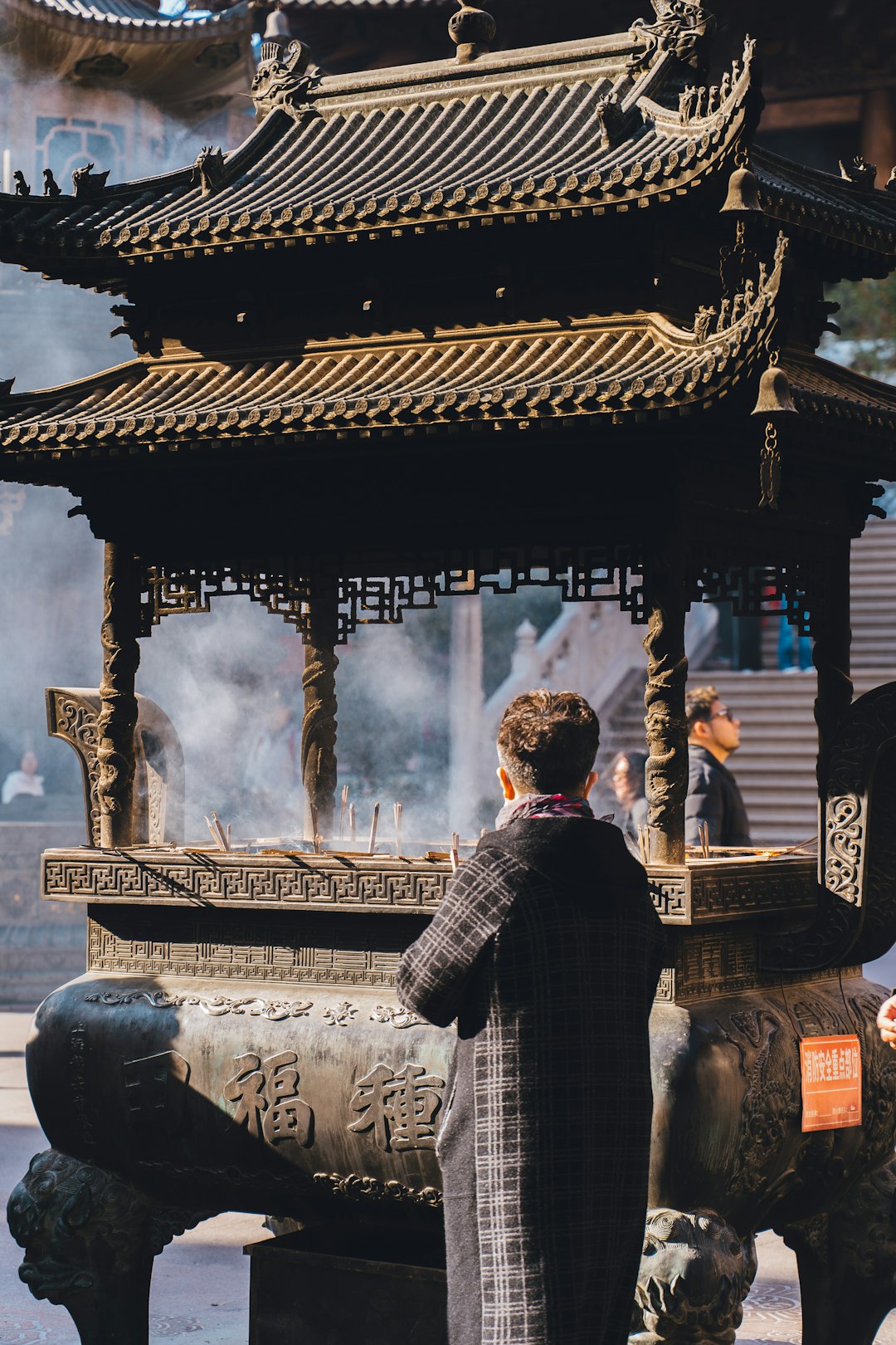Person praying at incense burner